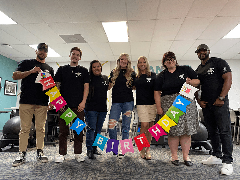 Pulse Marketing team holding birthday banner