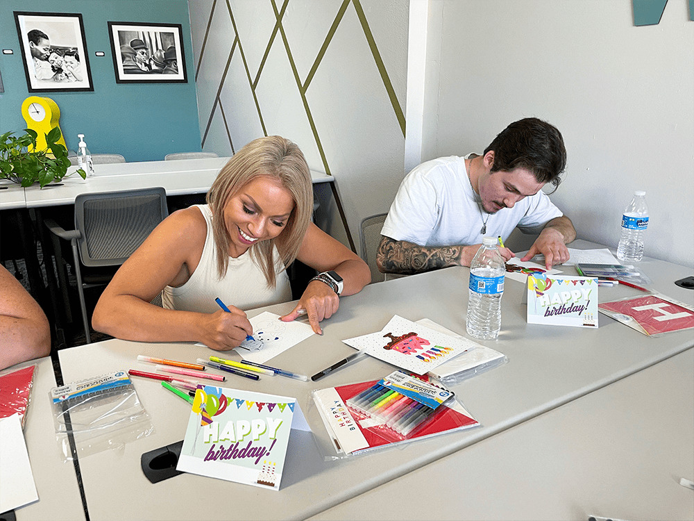 team members Serena and Kole coloring birthday banners