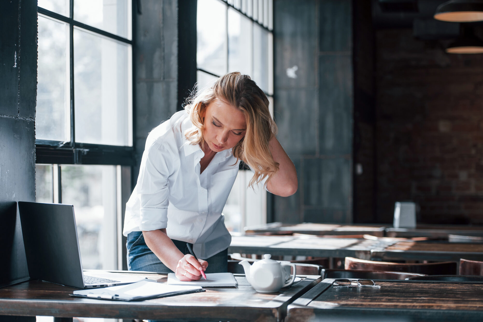 Final signatures. Businesswoman with curly blonde hair indoors in cafe at daytime Keep momentum going